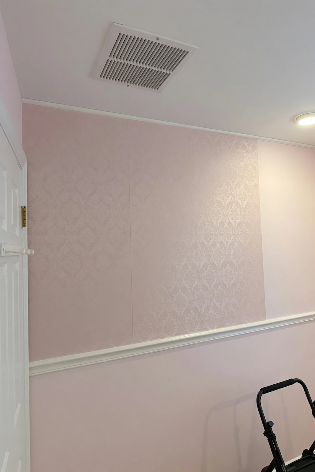 pink wallpaper above a chair rail in a Hicksville nursery