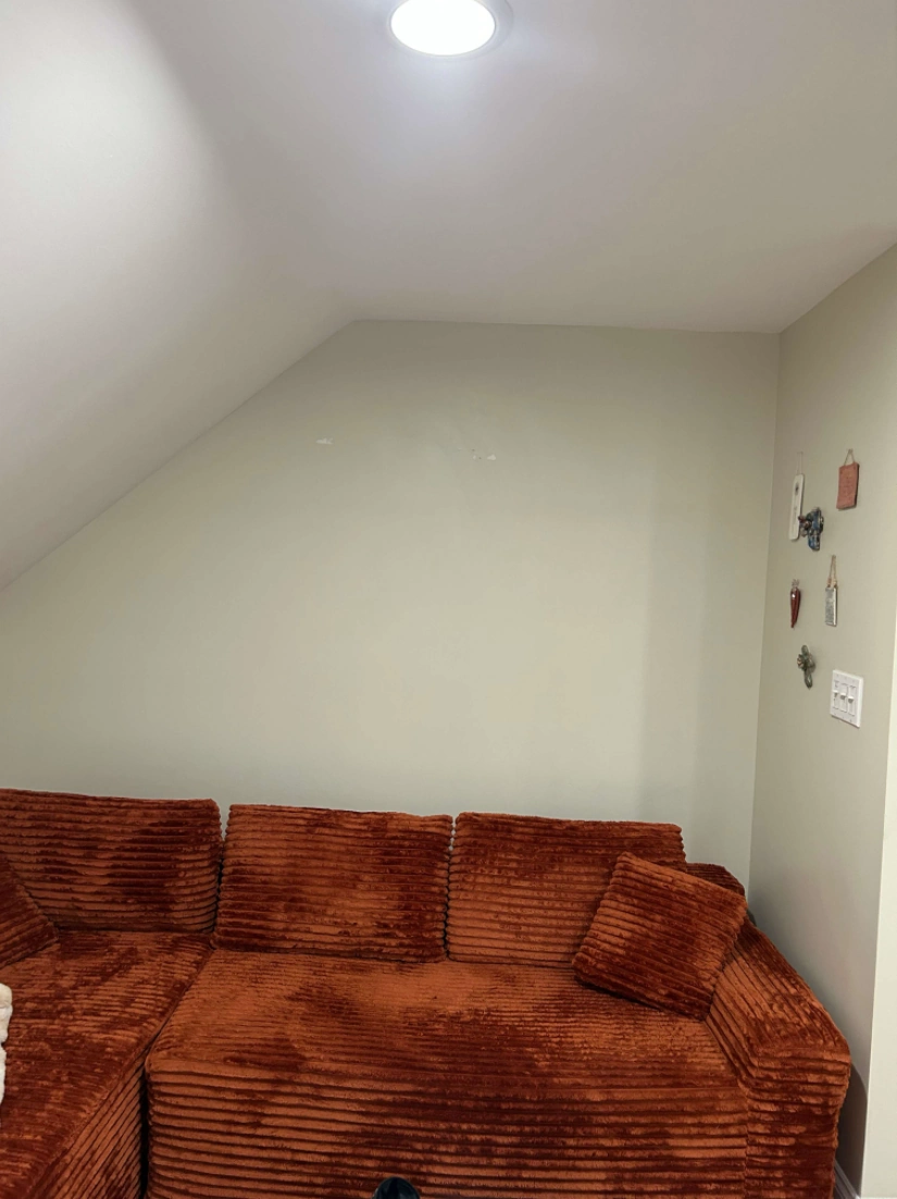 bare sloped-ceiling wall before textured wallpaper installation on Long Island