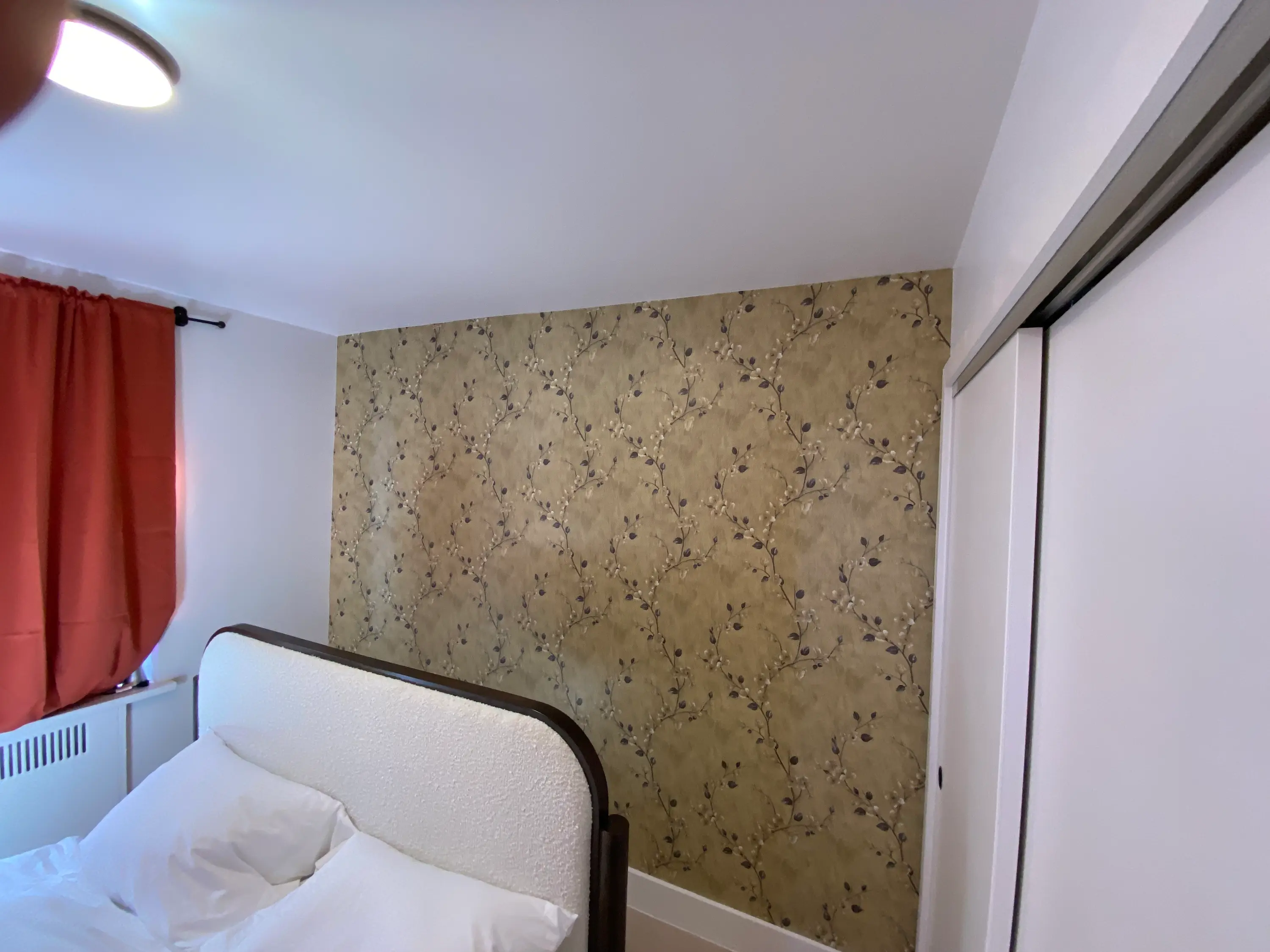 blossom branch peel & stick wallpaper behind the bed in a Lower Manhattan, NY bedroom