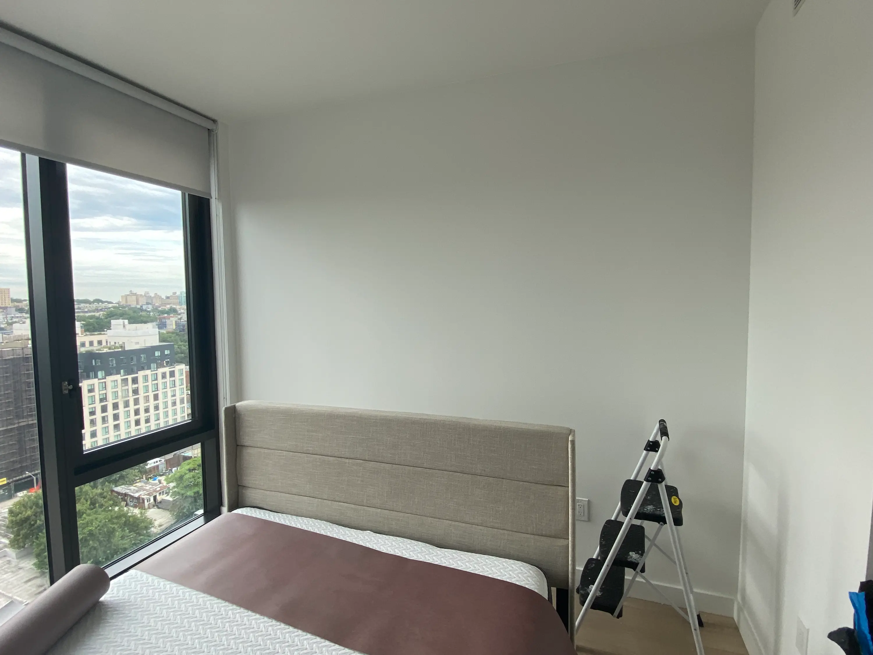 bare bedroom wall in a Brooklyn, NY high-rise before the mural wallpaper